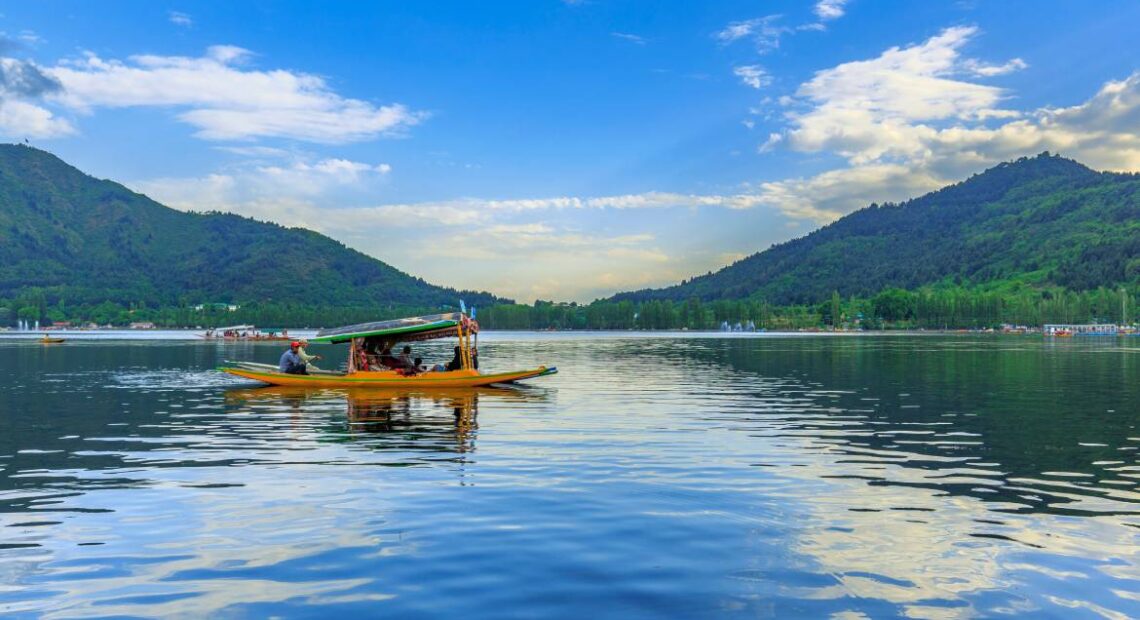 Shikara boat on Dal Lake with snow-capped mountains, Srinagar, Kashmir