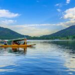 Shikara boat on Dal Lake with snow-capped mountains, Srinagar, Kashmir