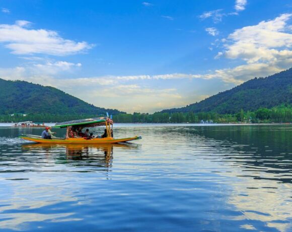 Shikara boat on Dal Lake with snow-capped mountains, Srinagar, Kashmir