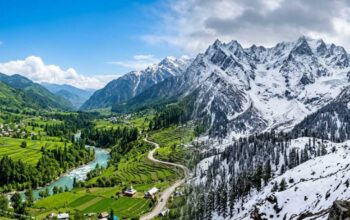 Panoramic view of lush green valleys and snow-capped mountains in Himachal Pradesh, representing the best season to visit Himachal.
