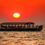 Couple on Kerala houseboat in golden evening light — best time to visit India for honeymoon
