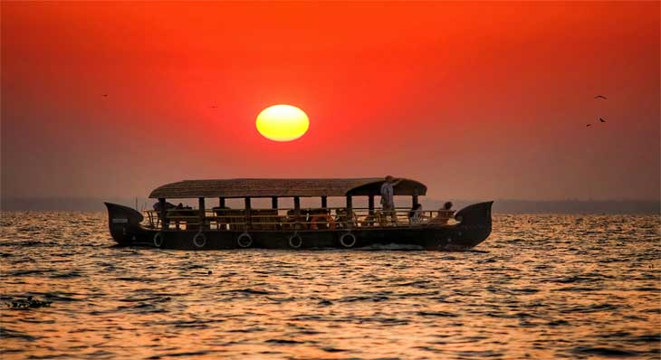 Couple on Kerala houseboat in golden evening light — best time to visit India for honeymoon