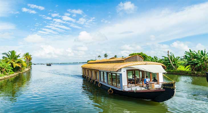 Traditional Kerala houseboat on the Alleppey backwaters at sunset — romantic honeymoon experience in South India